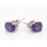 A pair of amethyst oval mixed cut silver set ear studs