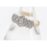 An early 20th Century diamond triple cluster dress ring, the brilliant cuts in white metal setting
