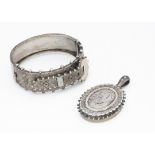 An articulated Edwardian white metal bangle, of buckle design together with a Victorian silver