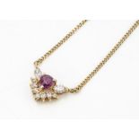 An 18ct yellow gold ruby and diamond necklace, claw set heart shaped ruby surrounded by marquise cut