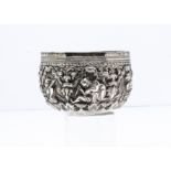 A small Burmese silver bowl, 9cm diameter, 3.6ozt, having raised design of figures in ornate