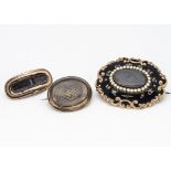 Three 19th Century mourning brooches, all of oval style centred with plaited hair panels, one with