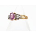 A ruby, diamond and white topaz dress ring, the oval ruby in claw setting flanked by colourless