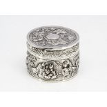 An early 20th Century Chinese white metal circular box, with raised scenes of figures, marked to