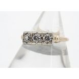 A three stone diamond ring, the old cut diamonds in square illusion settings, on yellow metal shank,