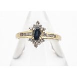 An 18ct gold sapphire and diamond cluster ring, the oval mixed cut claw set sapphire surrounded by