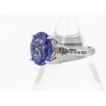 A platinum tanzanite and diamond contemporary dress ring, the oval mixed cut tanzanite in four