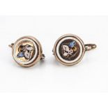 A pair of 19th Century gold and enamel circular earrings, centred with winged cherubs within a white