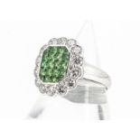A tsavorite and diamond tablet dress ring, of tablet shape with pave set green garnets surrounded by