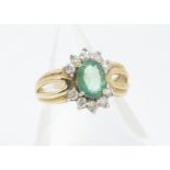 An emerald and diamond 9ct gold dress ring, the oval mixed cut with brilliant cut diamond set bezel,