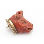 An early 19th Century Italian coral carved cows head, on a gold mount, the head missing horns and