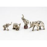 Four small modern silver figures of elephants, one balancing on an enamelled ball, 4.4cm, one larger