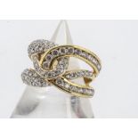 An 18ct gold and white stone set dress ring, the knotted shaped setting set with various white