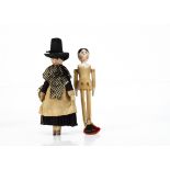 A pegged wooden doll, with tall Welsh style hat, dark woollen dress, black and white checked