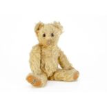 A small 1930s Merrythought teddy bear, with golden mohair, orange and black glass eyes, pronounced