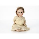 A Gebruder Heubach 8192 character baby, with brown sleeping eyes, brown mohair wig, bent-limbed