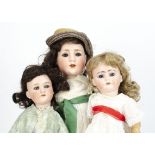 Three German bisque headed child dolls, a Schoenau & Hoffmeister Künstlerkopf doll with blue