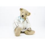 An early teddy bear 1910-20s, with blonde mohair, black glass eyes, large pronounced muzzle, black