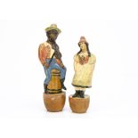 Two papier-mâché figural skittles circa 1900, one a black man seated on a barrel playing a violin