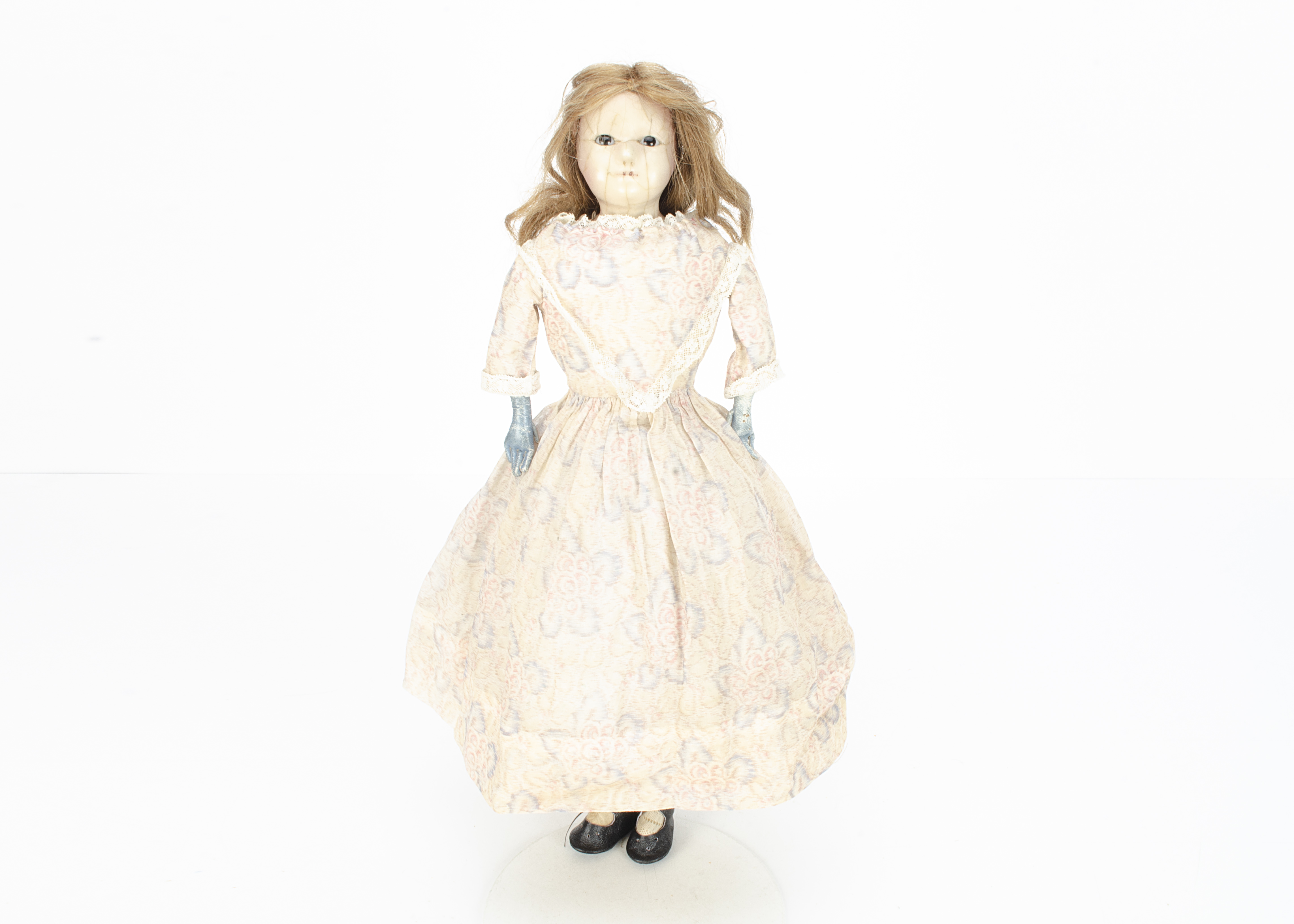 A mid 19th century English dipped wax over papier-mâché child doll, with fixed dark glass eyes,