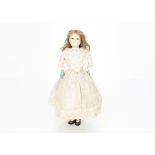 A mid 19th century English dipped wax over papier-mâché child doll, with fixed dark glass eyes,