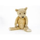 A 1930s Chiltern-type teddy bear, with golden mohair, orange and black odd sized glass eyes,