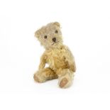 A post-war Chiltern Hugmee teddy bear, with golden mohair, orange and black glass eyes, muzzle