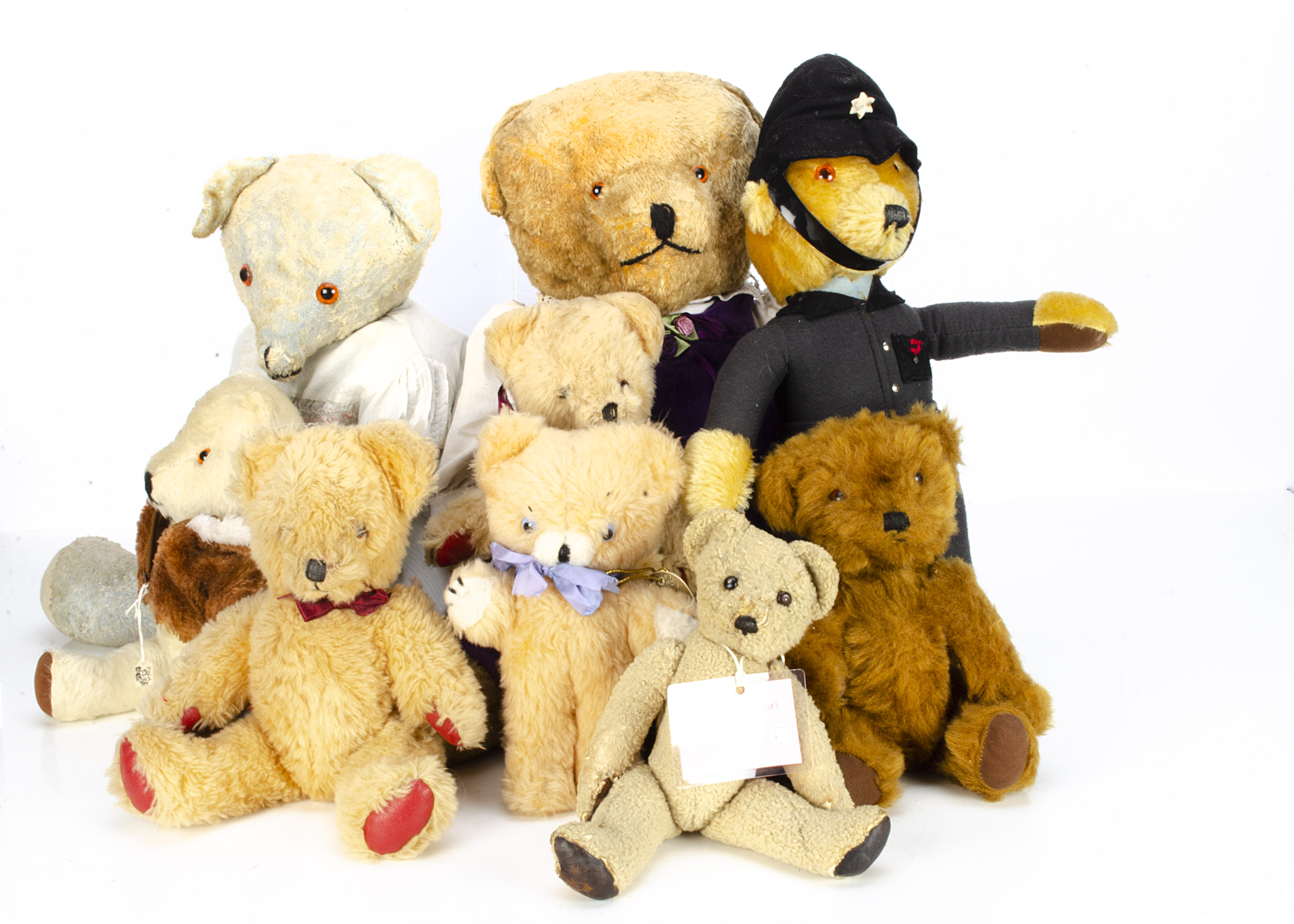 Nine post-war British teddy bears, a Merrythought policeman --18 ½in. (47cm.) high; two late Alpha