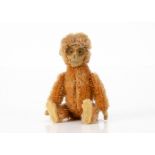 A Schuco miniature monkey compact and lipstick 1930s, with orange mohair, flocked tinplate face,