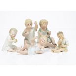 Five German bisque babies, one seated with an apple --5in. (12.5cm.) high, another holding and