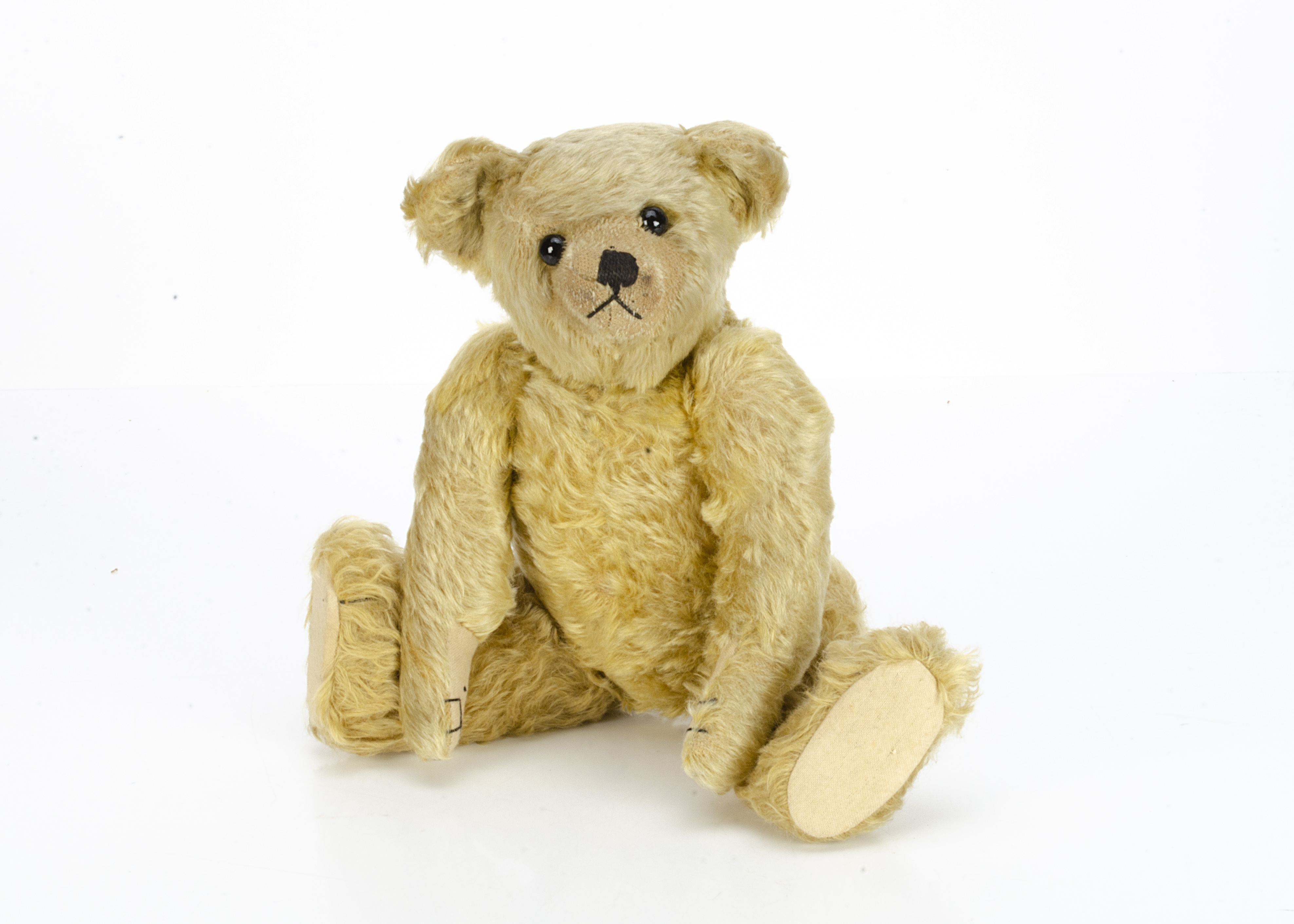 A fine Farnell teddy bear 1910s-20s, with blonde mohair, black boot button eyes, pronounced