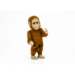 A German clockwork standing monkey 1930s, with brown mohair, pressed card face with brown and