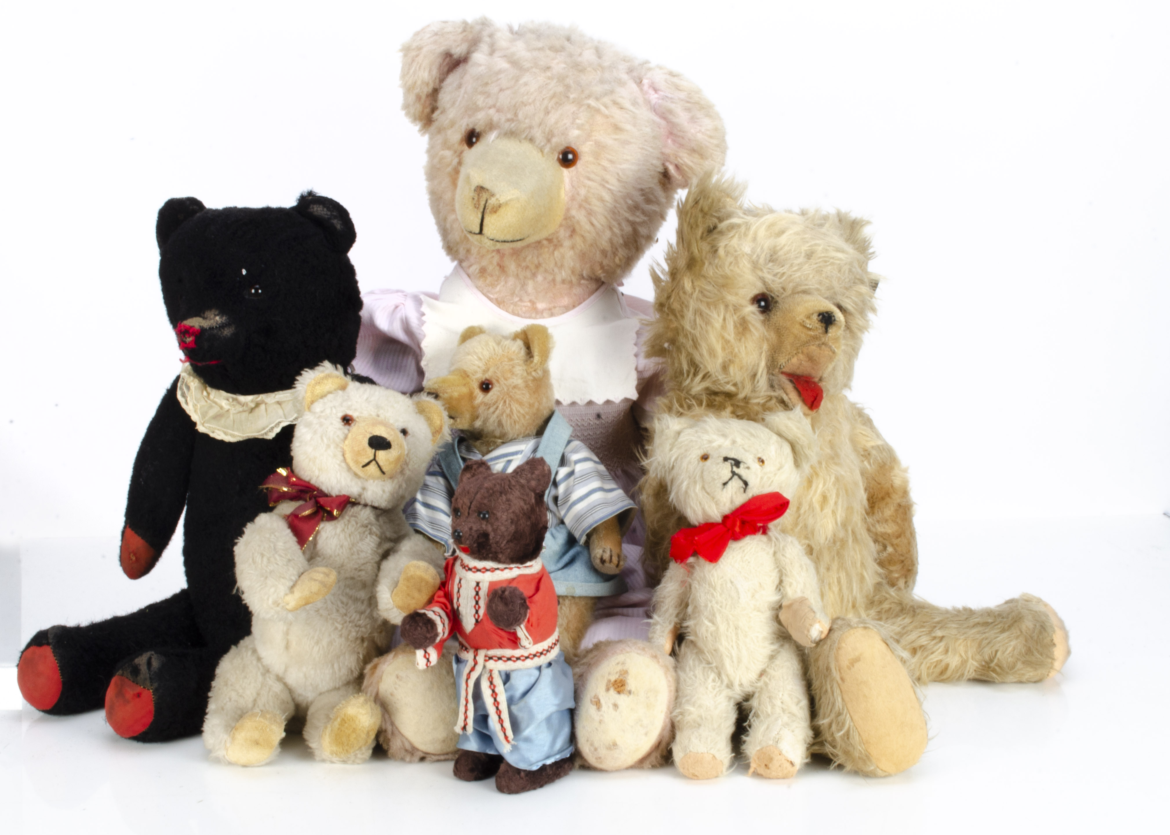 Seven European teddy bears, a Russian clockwork bear with brown artsilk plush and original Cossack