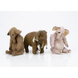 Three artist made elephants, of artificial silk plush, a pink elephant with swivel head and