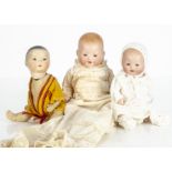 Three small German bisque headed baby dolls, an Oriental with dark sleeping eyes, closed mouth,