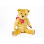 A post-war Chiltern Hugmee teddy bear, with golden mohair, orange and black glass eyes, muzzle