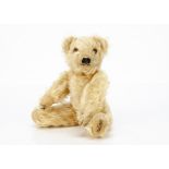 A small 1930s Merrythought teddy bear, with light golden mohair, orange and black glass eyes,