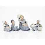 Four Gebruder Heubach Dutch children, all dressed in blue, a larger girl seated --7in. (18cm.) high;