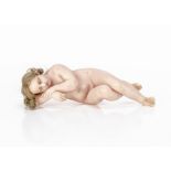 A 19th century poured wax Christ Child, asleep with insert blonde ringletted hair, lying on his side