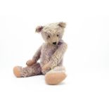 A German mauve mohair teddy bear 1930s, with orange and black glass eyes, pronounced clipped muzzle,