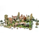 A 1930s English painted wood village scene, including a church, a timber framed house and another, a