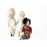 Three small German bisque headed dolls, a polar explorer or Eskimo with dark eyes, jointed