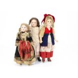 Three small bisque headed dolls, one with dark glass eyes, closed mouth, blonde mohair wig,