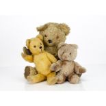 Three post-war British teddy bears, a Tara Toys musical bear with golden mohair, orange and black