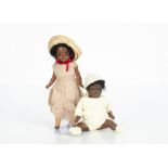 Two small German black dolls, a black bisque headed girl marked 812 with fixed dark glass eyes,