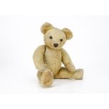 A 1920s Chad Valley teddy bear, with golden mohair, replaced brown and black glass eyes,