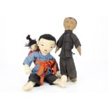 A primitive Chinese cloth male doll, with hand painted face, stuffed body, black trouser suit and