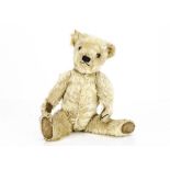 A 1930s Chiltern white mohair teddy bear, with orange and black glass eyes, black stitched nose,