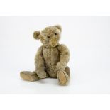 A Steiff teddy bear circa 1910, with blonde mohair, black boot button eyes, pronounced muzzle,