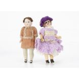 Two dolls' house dolls, a German bisque headed with dark glass eyes, brown mohair wig, jointed